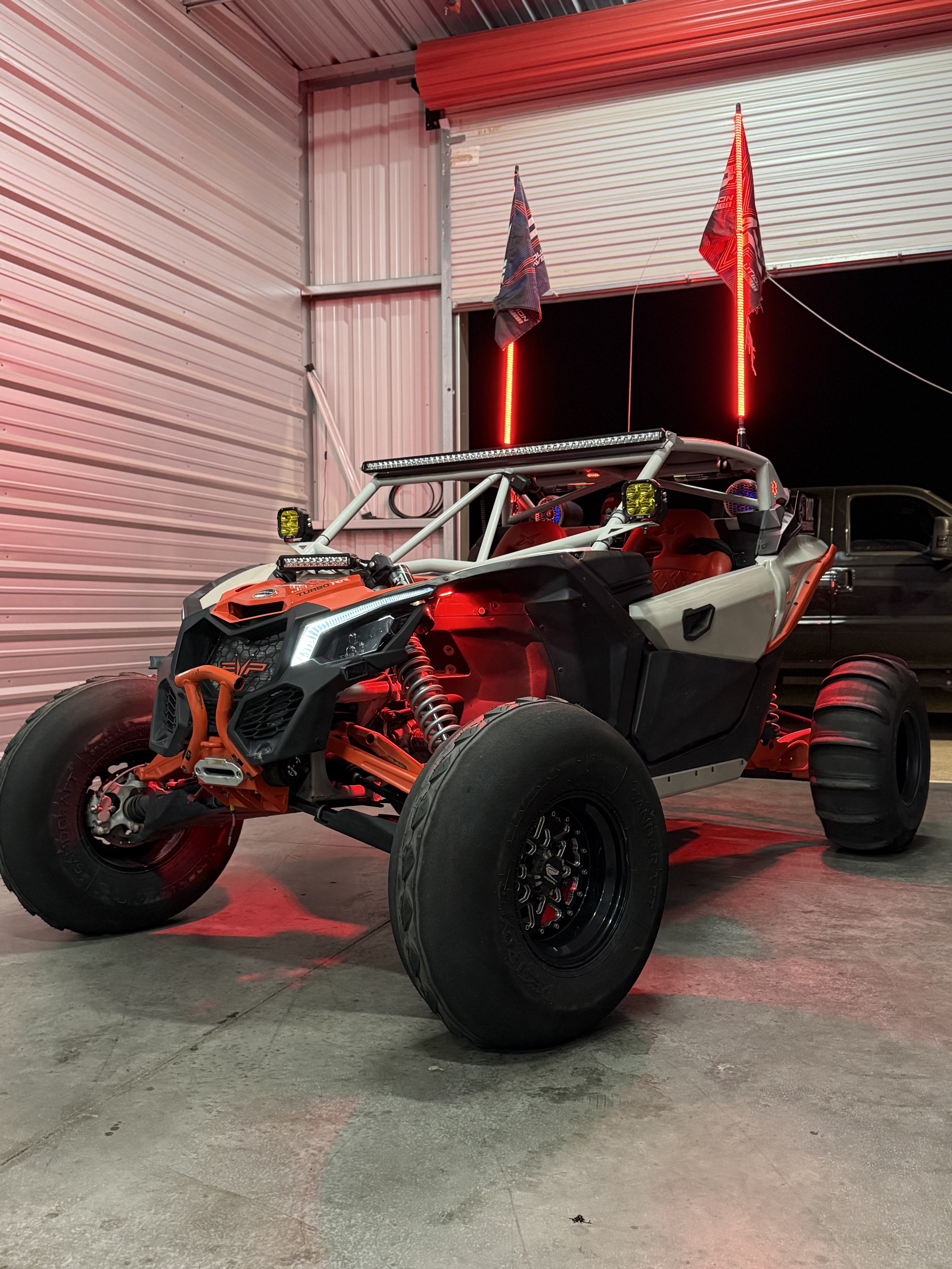 Custom red and white dune buggy with LED lights in industrial warehouse garage