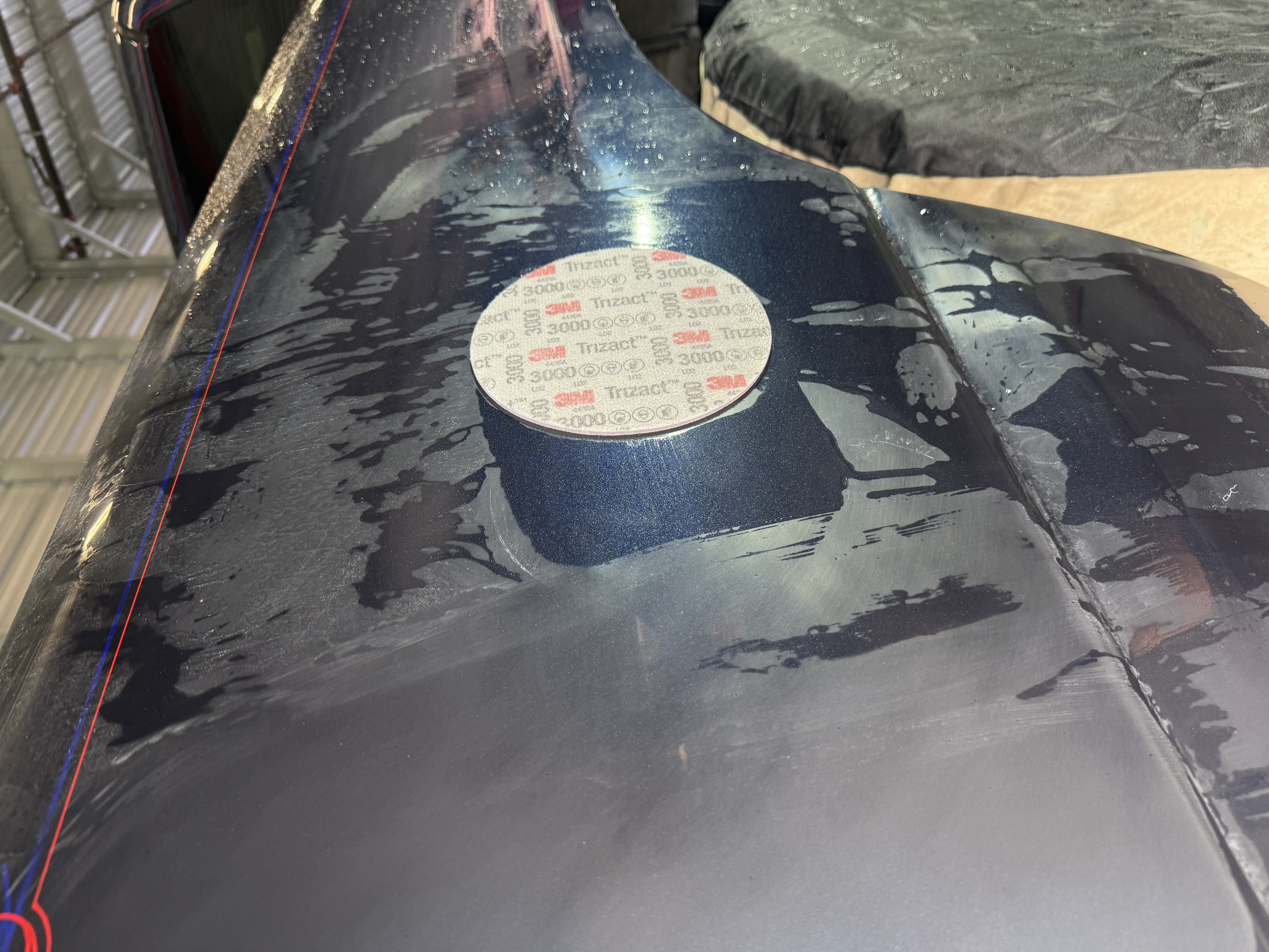 Dirty truck bed covered in dust with circular inspection patch and red stripe detail.