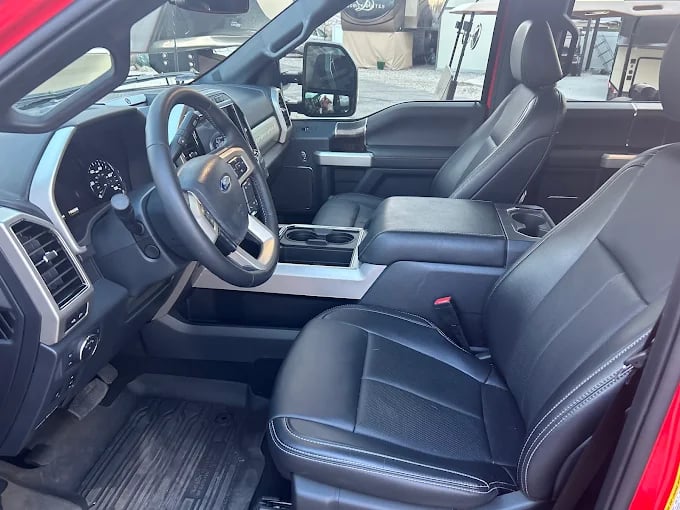 Modern pickup truck interior with black leather seats, steering wheel, and dashboard visible
