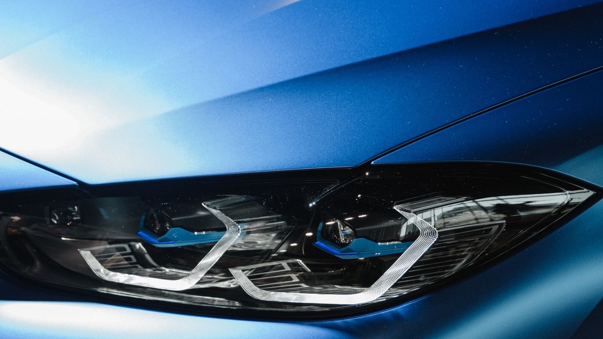 Close-up of blue car's LED headlights with angular chrome trim design